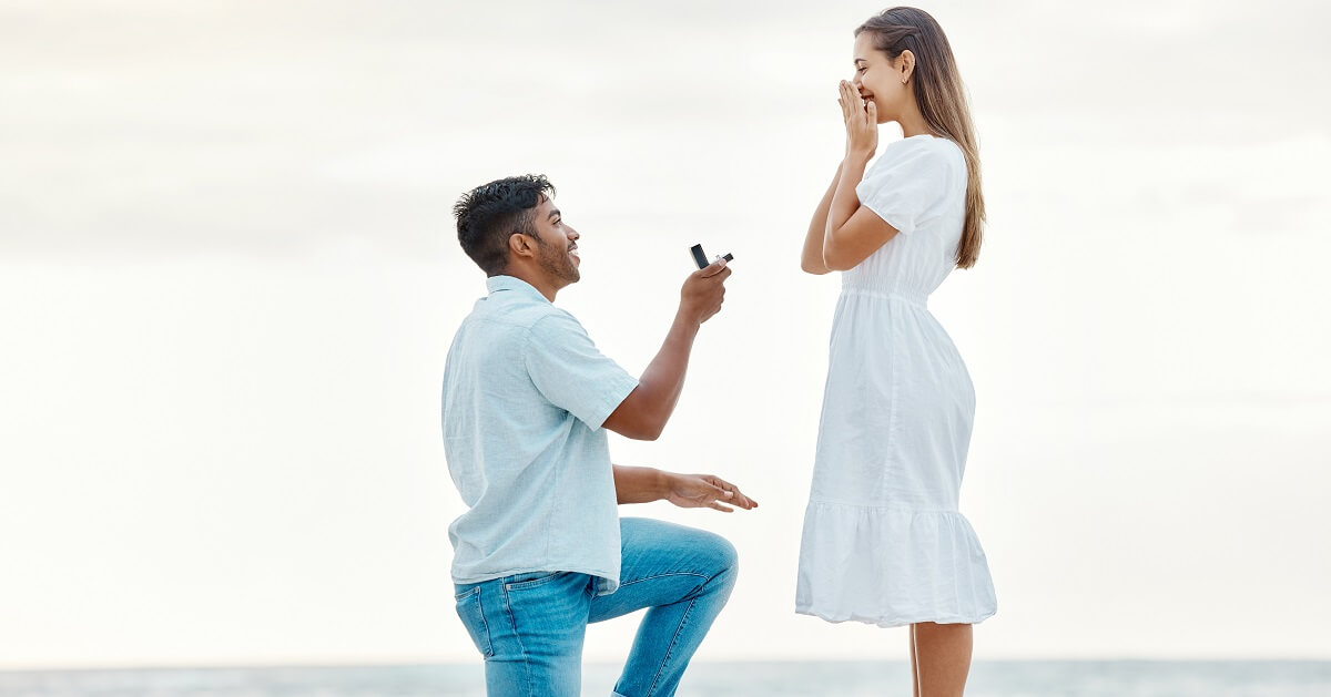 Homem a ajoelhar-se na praia