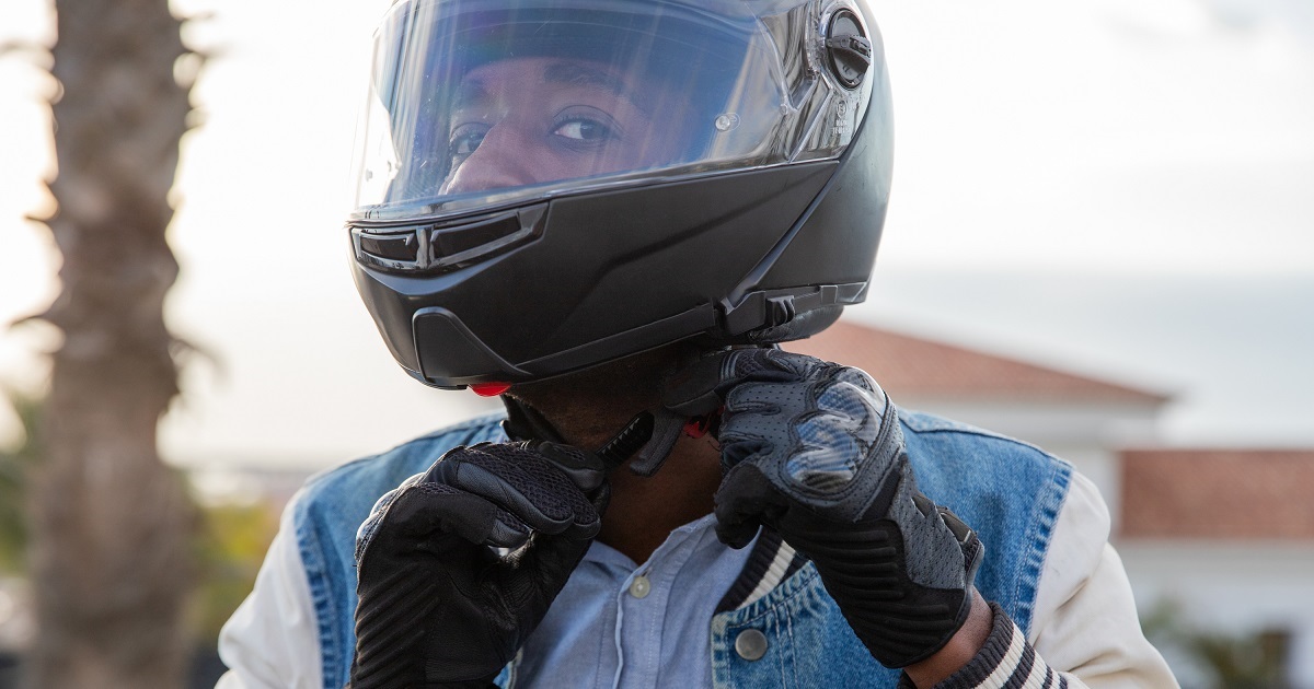 A motorcyclist tightens his helmet belt before driving his motorcycle